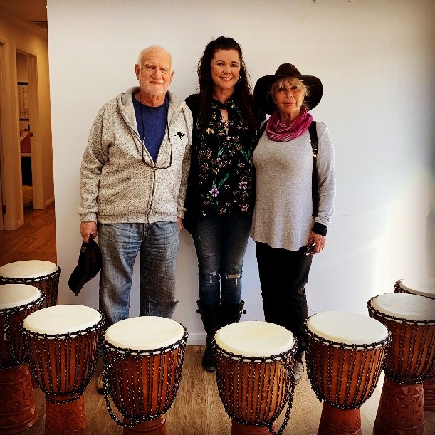 3 Bang the Drum participants standing behind drums. 