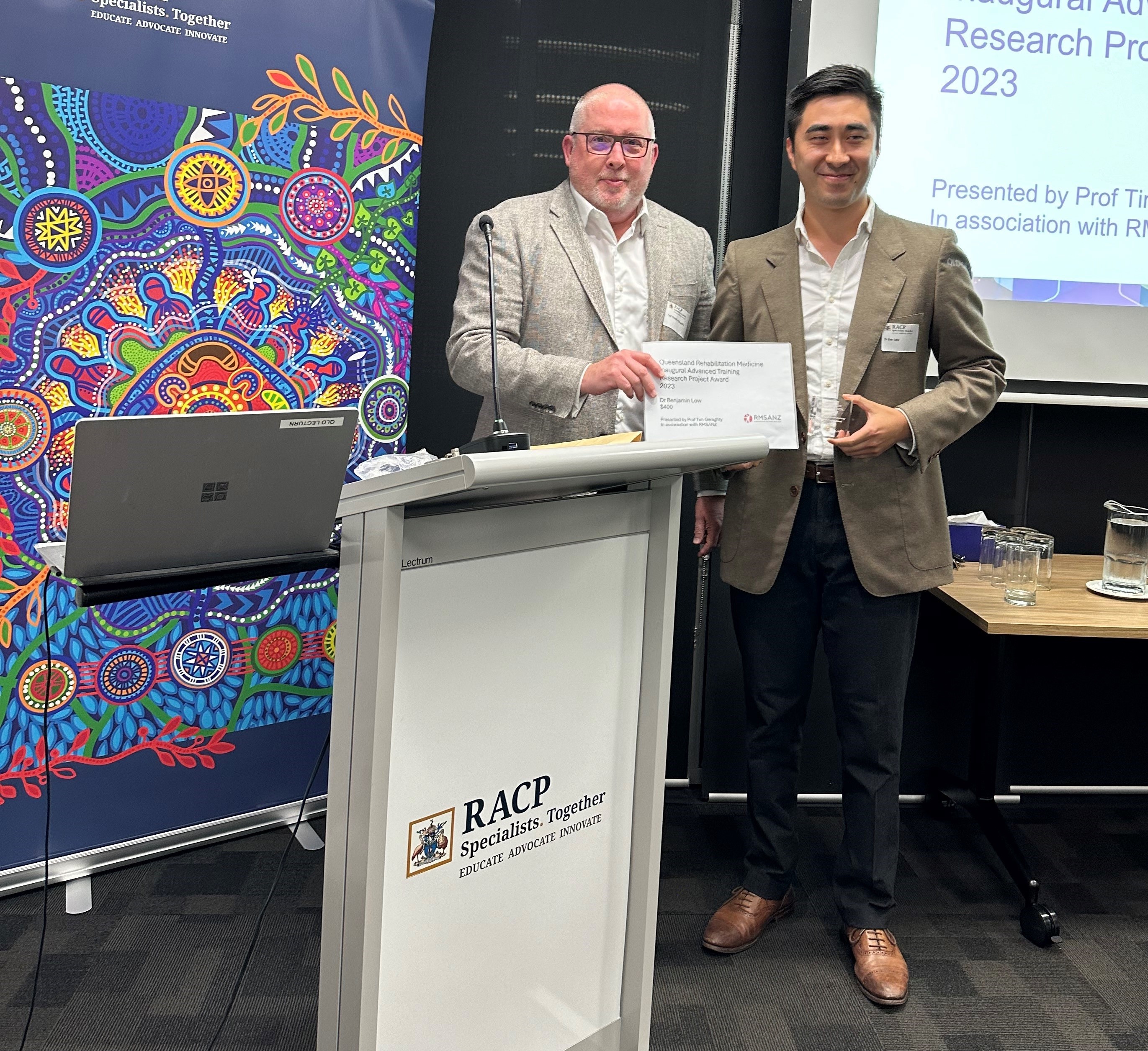 Tim Geraghty shaking hands with Ben Low as he presents Ben a certificate