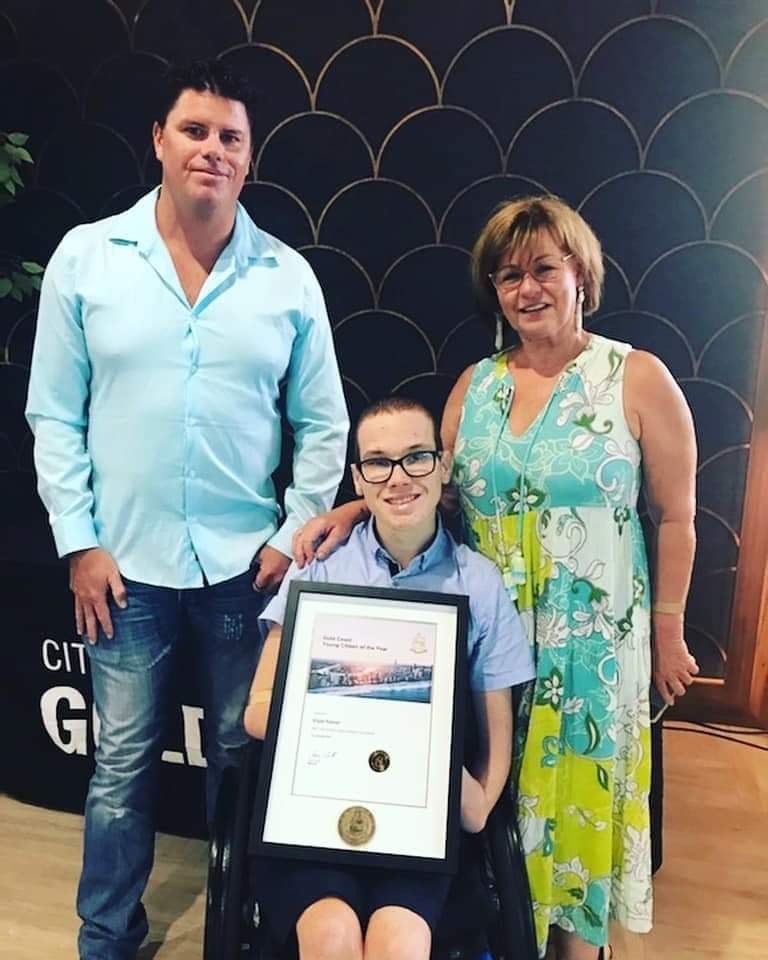 Elijah receiving his Australia Day award with coach Garth Plank and his mum Robyn. 