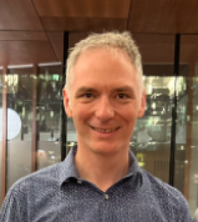 Profile image of Nick Aitcheson, a man with short grey hair, wearing a blue collared shirt.  